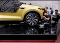  ?? AP/NG HAN GUAN ?? Chinese workers prepare for the Shanghai auto show at the city’s National Exhibition and Convention Center on Tuesday.