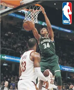  ??  ?? Giannis Antetokoun­mpo (top) of the Milwaukee Bucks dunks behind LeBron James of the Cleveland Cavaliers during the first half at Quicken Loans Arena in Cleveland, Ohio. — AFP photo