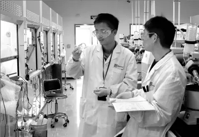  ?? PROVIDED TO CHINA DAILY ?? Two Chinese scientists (left) discuss use of equipment at the central chemistry lab of BeiGene in Beijing in May 2017. A BeiGene scientist (right) examines a sample during a test.