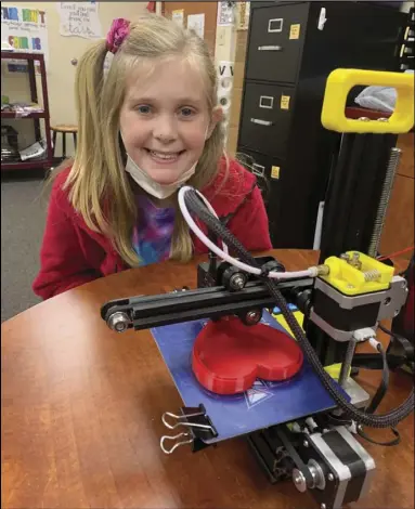  ??  ?? Left and above: Allison Smith and Gabe Hauger, fourth graders at Malvern Elementary School, use 3D printer to complete a project.
Special to the MDR