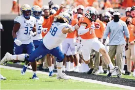  ?? BRODY SCHMIDT/ASSOCIATED PRESS ?? Tulsa’s Deven Lamp (58) chases Oklahoma State receiver Dillon Stoner (17) out of bounds in the first half. The host Cowboys scratched out a 16-7 victory in Stillwater.