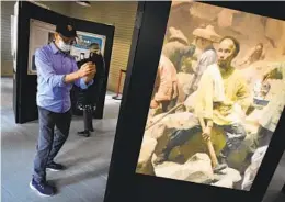  ?? AP ?? Ed Hung takes a photo of a Chinese laborer in an exhibit in the restored 1917 Chinese Laundry Building after its dedication in Yosemite National Park on Friday.