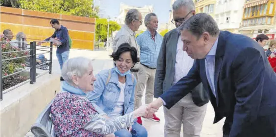  ?? CÓRDOBA ?? Luis Planas y Esteban Morales, durante el paseo electoral por Puente Genil, saludan a una anciana.