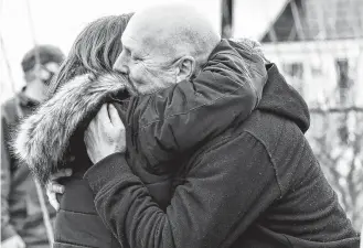  ?? TINA COMEAU ?? Paramedic Danny Deveau, a close friend who had also been a partner with Terry Muise, receives a hug from nurse Pam Sullivan outside Muise’s home. First responders, hospital staff, family and friends came out to pay tribute to Muise who was known as a mentor throughout his 44-year career as a paramedic. Muise died on Feb. 9, the day of the tribute.