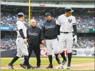  ?? Jim McIsaac / Getty Images ?? Aaron Judge (99) of the New York Yankees is checked on by bench coach Josh Bard, trainer Steve Donohue and first-base coach Reggie Willits (50) prior to leaving a game against the Kansas City Royals in the sixth inning at Yankee Stadium on Saturday in New York.