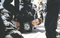  ?? ASSOCIATED PRESS FILE PHOTO ?? A demonstrat­or lies on the ground as he is handcuffed during a free speech rally Aug. 27 in Berkeley, Calif. The City Council voted Tuesday to allow police to use pepper spray during the kind of violent protests that have rocked the city this year.