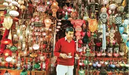  ??  ?? A shop owner holds cups of tea outside his shop in Istanbul’s Grand Bazaar, one of Istanbul’s main tourist attraction­s.