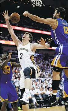  ?? Gerald Herbert / Associated Press ?? Pelicans center Omer Asik (3) is blocked by Warriors center Andrew Bogut while driving to the basket in the second half.