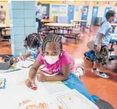  ?? BRITTAINY NEWMAN/AP ?? Students write and draw positive affirmatio­ns on poster board in August at an elementary school in the Bronx borough of New York.