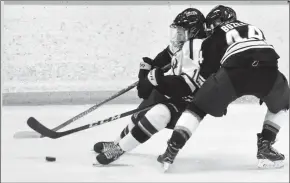  ?? Herald photo by Tijana Martin ?? Brett Campbell of the University of Lethbridge Pronghorns, left, and Kennedy Bozek of the Mount Royal University Cougars battle for the puck during a home game on Friday night.