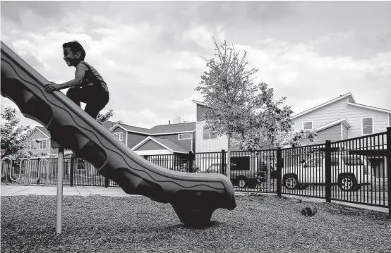  ?? Michael Ciaglo photos / Houston Chronicle ?? Damian Amya, 6, climbs up a slide while playing tag with his brother at a park in the Near Northside’s Avenue Place affordable housing developmen­t.