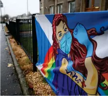  ??  ?? A Saltire flag with an NHS supporting cartoon on it sits on a fence in Bannockbur­n near Stirling