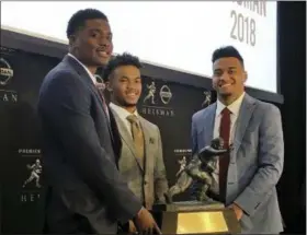  ?? RALPH RUSSO — THE ASSOCIATED PRESS ?? Heisman Trophy finalists, from left, Dwayne Haskins, from Ohio State, Kyler Murray, of Oklahoma, and Tua Tagovailoa, from Alabama, pose with the Heisman Trophy at the New York Stock Exchange, Friday in New York.