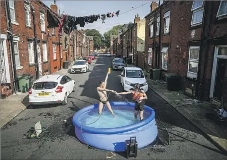  ?? Christophe­r Furlong Getty Images ?? IN LEEDS in northern England, residents stay outside to make the best of the hot day. Few households in Britain have air conditioni­ng.