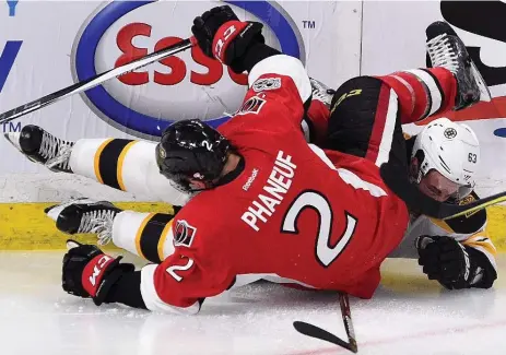  ?? SEAN KILPATRICK/THE CANADIAN PRESS ?? Boston‘s Brad Marchand and Ottawa’s Dion Phaneuf get tangled up Wednesday. Marchand scored the winner in a 2-1 rally past the Senators.