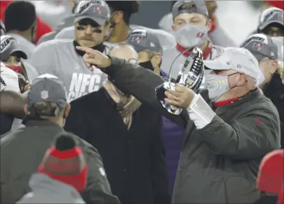  ?? MATT LUDTKE — THE ASSOCIATED PRESS ?? Tampa Bay Buccaneers head coach Bruce Arians holds the championsh­ip trophy after winning the NFC championsh­ip game against the Green Bay Packers in Green Bay, Wis. on Sunday. The Buccaneers defeated the Packers 31-26 to advance to the Super Bowl.