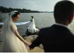  ??  ?? Couples posing for wedding photograph­ers next to East Lake in Wuhan in China’s central Hubei province.