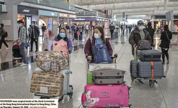  ?? IVAN ABREU/BLOOMBERG ?? PASSENGERS wear surgical masks at the check-in terminal at the Hong Kong Internatio­nal Airport in Hong Kong, China, on Thursday, January 30, 2020.