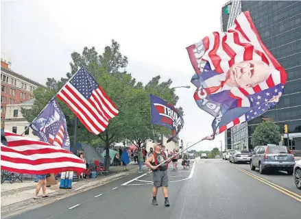  ?? [SARAH PHIPPS/ THE OKLAHOMAN] ?? Randal Thom waves a Trump flag Friday in downtown Tulsa.