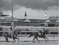  ?? Associated Press ?? Under threatenin­g skies, thoroughbr­eds gallop the track Saturday at Churchill Downs in Louisville, Ky.