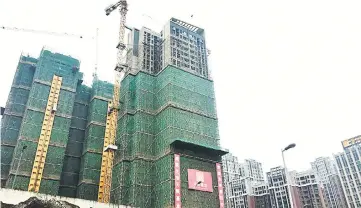  ??  ?? Buildings under constructi­on are pictured in Chengdu, Sichuan province. China is expected yesterday to post a modest slowdown in fourth quarter economic growth from the previous three months as the government extended a crackdown on debt risks and...