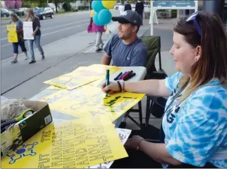  ?? RON SEYMOUR/The Daily Courier ?? Striking casino workers Kevin Muir, centre, and Courtenay Ferland, right, work on new signs Tuesday while others walk the picket line outside the Playtime Casino on Water Street in downtown Kelowna.