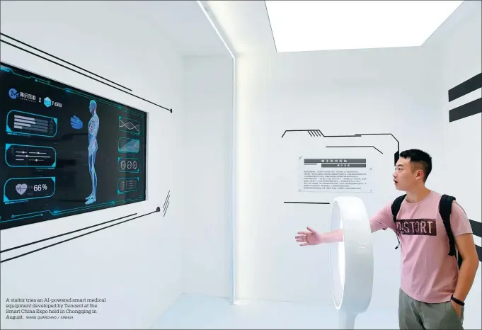  ?? WANG QUANCHAO / XINHUA ?? A visitor tries an AI-powered smart medical equipment developed by Tencent at the Smart China Expo held in Chongqing in August.