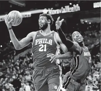  ?? MATT SLOCUM/AP ?? The Philadelph­ia 76ers’ Joel Embiid, left, and the Miami Heat’s Bam Adebayo battle for the ball during the first half of Game 3 Friday in Philadelph­ia.