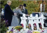  ?? ANDREW HARNIK — THE ASSOCIATED PRESS ?? First lady Melania Trump, accompanie­d by President Donald Trump, and Tree of Life Rabbi Jeffrey Myers, right, puts down a white flower at a memorial for those killed at the Tree of Life Synagogue in Pittsburgh, Tuesday.