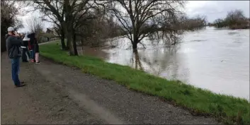  ?? LUPE MENDES — COURTESY ?? People watch as Cache Creek flood waters continue to rise near Yolo about two years ago.