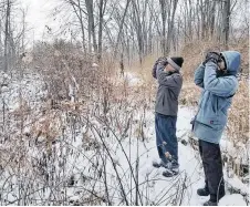  ?? TODD HAGEDORN PHOTO ?? Two participan­ts in a birdathon use binoculars to search for birds.