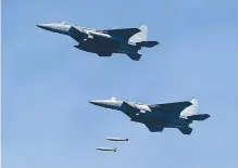  ?? Yonhap ?? F-15K fighter jets drop MK84 multipurpo­se bombs at a live-fire range near the inter-Korean border in Taebaek in a show of overwhelmi­ng force after President Moon Jae-in ordered the military to display its capabiliti­es that can sternly respond to North Korea’s provocatio­ns.