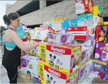  ?? TONY GUTIERREZ/AP ?? Volunteer Elizabeth Haley organizes boxes of diapers donated for hurricane Harvey victims at a Dallas drop-off location.