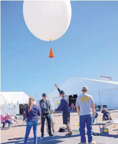  ?? PHOTO BY ANGELINA PEACE/AIBF ?? Guests watch as students learn about the equipment used to track the flight of gas balloons at the 7-Eleven Balloon Discovery Center.