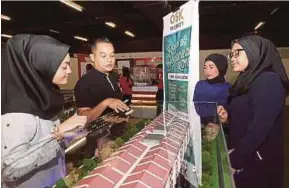  ?? PIC BY SHARUL HAFIZ ZAM ?? OSK senior sales consultant Muhammad Tarmizi Omar (second from left) briefing visitors on low-cost houses sold at the MyRumah Property Exhibition on Friday.