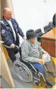  ?? FOTO: DPA ?? Hans K. wird in einem Rollstuhl in einen Saal des Landgerich­ts Memmingen geschoben.
