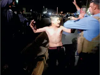  ?? PHOTO: REUTERS ?? Iraqi security forces detain a boy after removing a suicide vest from him in Kirkuk, Iraq, on Monday.