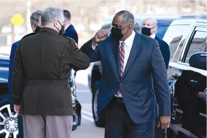  ?? The Associated Press ?? Q Defense Secretary Lloyd Austin, right, greets Chairman of the Joint Chiefs of Staff Mark Milley as he arrives Friday at the Pentagon in Washington.