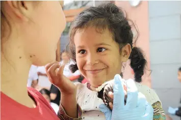  ?? COURTNEY AFRICA African News Agency (ANA) ?? BLU Holloway, 4, enjoys a cupcake with Elaine Rudolph from Rainbow Garden Village at the Christmas lunch, hosted for more than 600 homeless people in Church Street yesterday. |