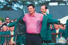  ?? AFP ?? Patrick Reed is presented with the green jacket by Sergio Garcia during the ceremony at Augusta National Golf Club.