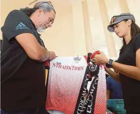  ?? MOHD HANIF
PIC BY SURIANIE ?? Datuk Ahirudin Attan and his daughter, Ahirine, looking at the race jersey after collecting their goodie bags and race kits for the NST CCycle Challenge at Balai Berita in Bangsar yesterday.