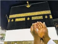  ?? AP PHOTO/DAR YASIN ?? A Muslim pilgrim prays Friday near the Kaaba, the cubic building at the Grand Mosque, ahead of the annual hajj pilgrimage, in the Muslim holy city of Mecca, Saudi Arabia.