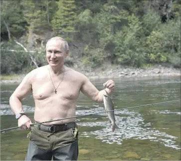  ?? Alexei Nikolsky Kremlin Pool Photo ?? RUSSIAN PRESIDENT Vladimir Putin displays a catch while vacationin­g near the Mongolian border. He also went spearfishi­ng, venturing underwater on a two-hour hunt to capture a pike, his spokesman said.