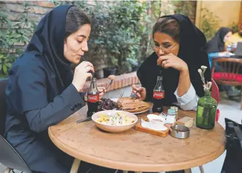  ??  ?? Iranian customers drink Coca-cola at a cafe in downtown Tehran, Iran, this summer. Coca-cola held a 28 percent market share in Iran, according to a 2016 report, while Pepsi had around 20 percent.