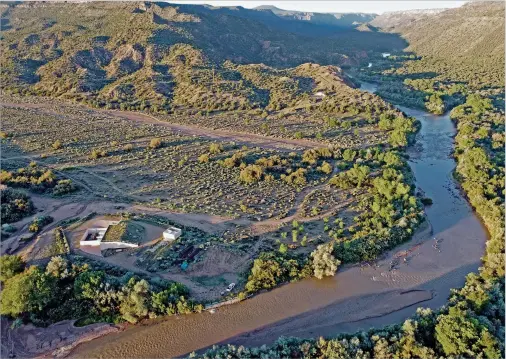  ?? LUIS SÁNCHEZ SATURNO/THE NEW MEXICAN GABRIELA CAMPOS/THE NEW MEXICAN ?? ABOVE: An aerial view of the Buckman Direct Diversion on Friday. Officials with the city of Santa Fe say conservati­on efforts over the past 25 years have allowed natural water sources to recharge, positionin­g the city to handle growth.
RIGHT: JJ Sell uses a forklift Friday to lift cabinets at the Siler Yard apartments under constructi­on on Siler Road.