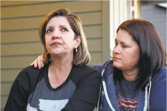  ?? Elaine Thompson / Associated Press ?? Las Vegas shooting survivors Chris Gilman (right) comforts her wife, Aliza Correa, as tears well at their home in Bonney Lake, Wash., while they discuss the Las Vegas shooting attack.