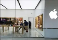  ?? (AP PHOTO/LYNNE SLADKY, FILE) ?? In this March 142020file photo, Apple employees work inside a closed Apple store in Miami.