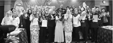  ??  ?? Fatimah (fifth right), Noriah (fourth right) and others show their palms in a ‘STOP’ – symbolisin­g the call to put an end to domestic violence.