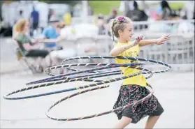  ??  ?? Sophie Spynda of Bloomfield finds a clear spot at the McKees Rocks “Feastival” Saturday to work on her hula-hoop skills.