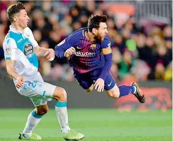  ?? AFP ?? Lionel Messi (right) and Deportivo La Coruna’s Fabian Schaer eye the ball during their Spanish league football match at the Camp Nou stadium in Barcelona on Sunday. Barcelona won 4-0. —